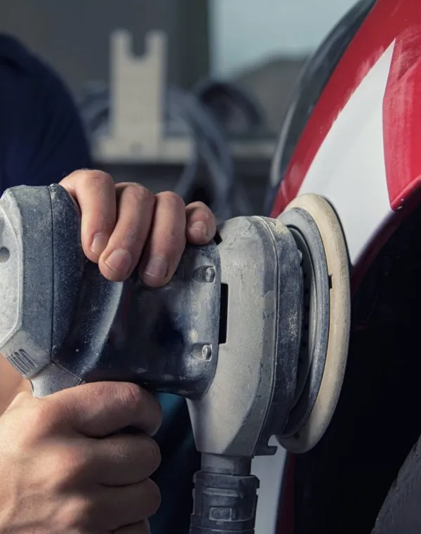 A Man Who Sanding With A Grinder And Prepares The Paint For The Car In A Car Service